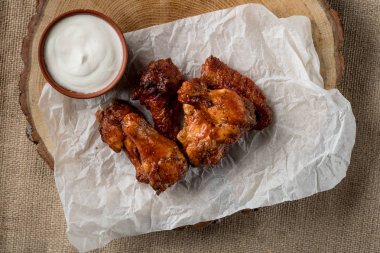 ahşap tahta kase, üstten görünüm peynir sos ile servis üzerinde kavrulmuş tavuk kanatları