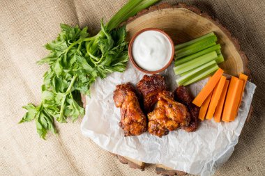 Buffalo kanatlar sebze dilimleri ile rustik arka plan üzerinde tavuk