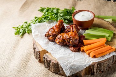 Buffalo kanatlar sebze dilimleri ile rustik arka plan üzerinde tavuk