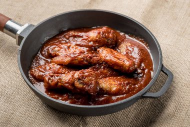 demir tavada kırmızı soslu kızarmış tavuk görünümünü kapat