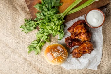 Buffalo tavuk kanatları ve ahşap tahta kase, kopya alanı ile üstten görünüm peynir sos ile servis üzerinde susam ile topuz