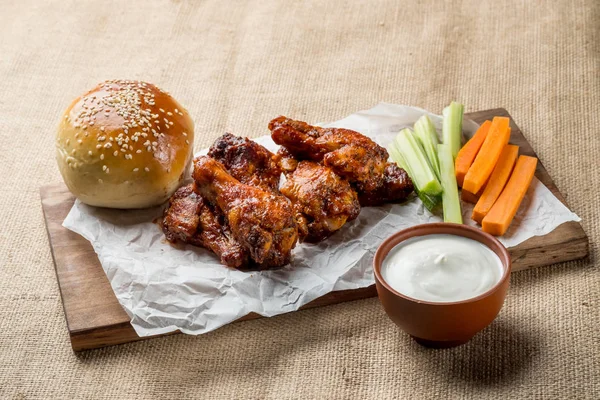 Buffalo kanat tavuk ve topuz ile susam ahşap tahta üzerinde peynir sosu ve kereviz ve havuç ile servis sopa