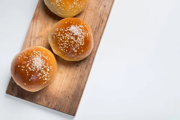 Närbild Tre Färska Bullar Med Sesam Träskiva Ovanifrån Med Kopia — Stockfoto