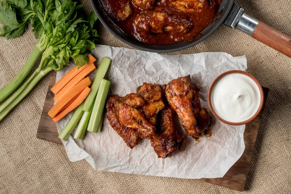 Sebze çubukları ve peynir soslu beyaz masada Buffalo tavuk