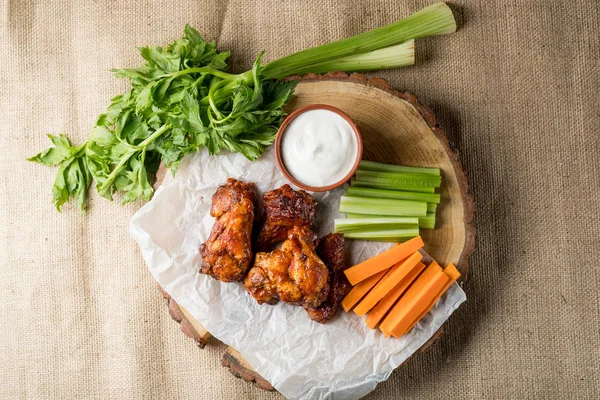 Buffalo kanatlar sebze dilimleri ile rustik arka plan üzerinde tavuk