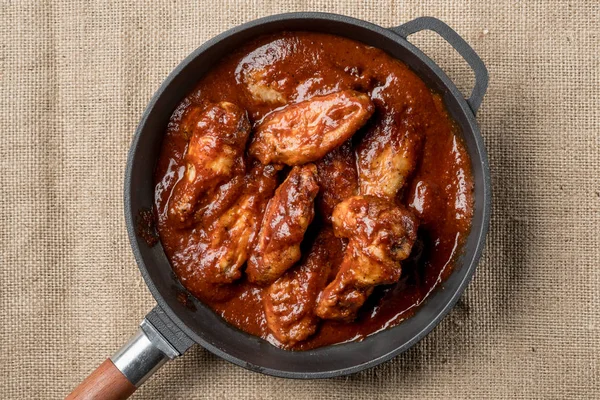 Üstten Görünüm demir tavada kırmızı sos ile kavrulmuş tavuk