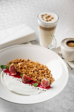 Granola incir ve yoğurt kahve fincanı, beyaz tablo ile yakın çekim