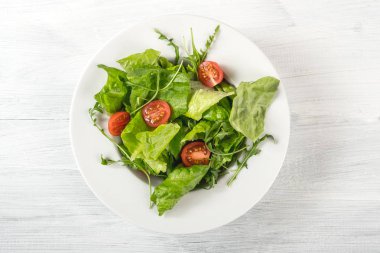 taze salata domates ve yeşil beyaz plaka üzerinde