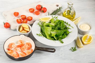 salata karides, yeşillik, domates, zeytin yağı, sos ve tost beyaz tahta masada yemek pişirmek için malzemelerin Üstten Görünüm