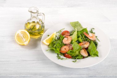 salata karides ve sebze plaka üzerinde ve zeytinyağı Beyaz ahşap tablo