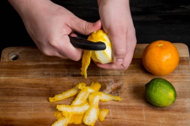 limon bıçakla ahşap tahta üzerinde peeling Şef eller yakın çekim