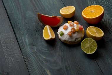 Üstten Görünüm siyah ahşap arka plan üzerine beyaz buzlanma ve renk meyve parçaları ile pasta