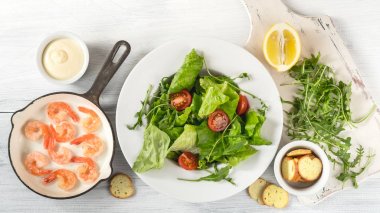 salata karides, yeşillik, domates, sos ve tost beyaz tahta masada yemek pişirmek için malzemelerin Üstten Görünüm