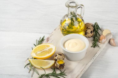 bıldırcın yumurtası, zeytinyağı, limon, sarımsak ve biberiye Beyaz ahşap kesme tahtası üzerinde sos, görünümü kapatın 