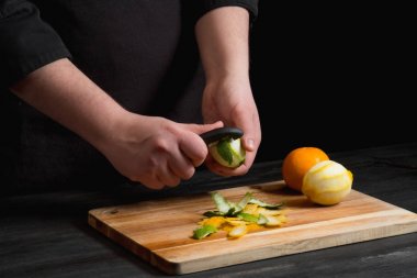 Şef eller kireç bıçakla ahşap tahta üzerinde peeling..