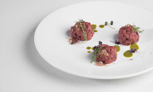 Beef raw chopped meat with spices, herbs and egg served on white plate isolated with copy space