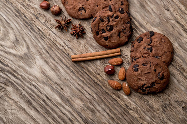 Домашнее печенье из чипсов со специями и орехами на деревянном фоне, вид сверху с местом для копирования
