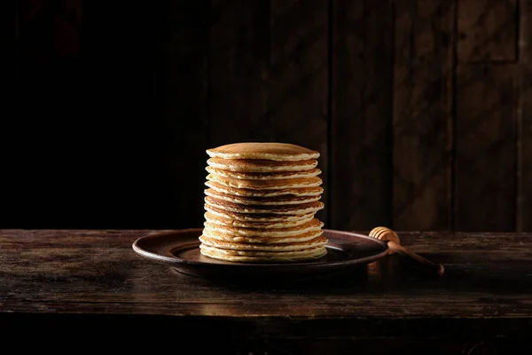 木制深色底色的蜂蜜糖浆煎饼堆栈 — 图库照片