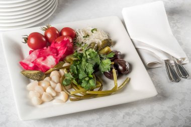 Turşu yeşillik, domates, kırmızı biber, salatalık, zeytin ve sarımsak ile hizmet