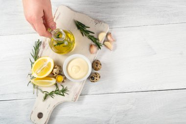 Şef el sos ile Bıldırcın yumurta pişirme. zeytinyağı, limon, sarımsak ve biberiye beyaz masa, kopya alanı ile üstten görünüm üzerinde