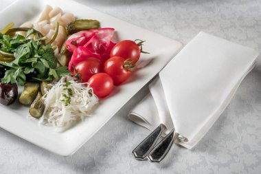 Turşu yeşillik, domates, kırmızı biber, salatalık, zeytin ve sarımsak ile hizmet