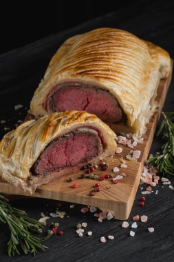 beef Wellington otlar ve baharatlar ile ahşap tahta üzerinde kapat