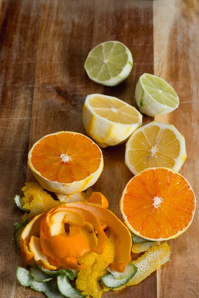 peeled citrus fruits on wooden background, top view with copy space