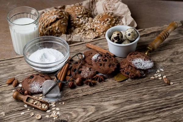 homemade cookies with sugar powder, quail eggs and glass of milk on wooden background