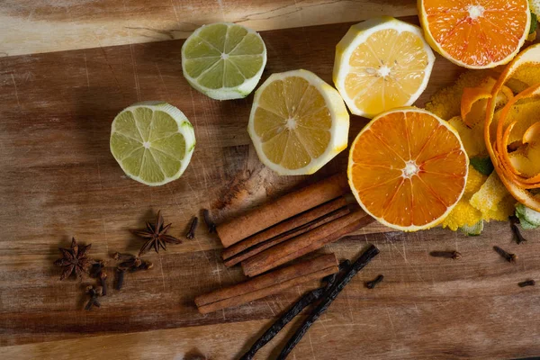 peeled citrus fruits and spices on wooden background, top view