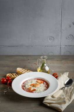 Domates çorbası kruton ekmek ve karides ahşap gri mutfak masasında