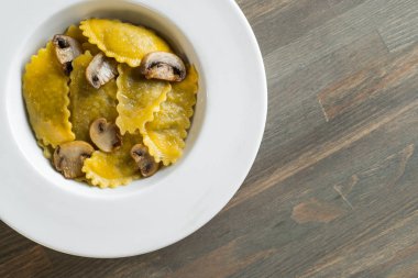 Karanlık ışık arka planda mantarlı makarna mantı. Ev yapımı geleneksel İtalyan yemekleri fotoğraf.