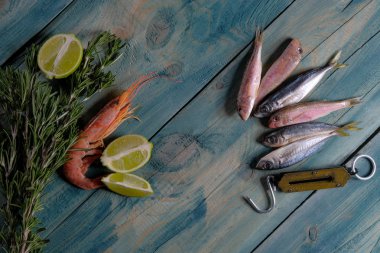 Karides deniz ürünleri ve balık kireç ve mavi ahşap bir masa üzerinde otlar ile. Yer alan metin ve menü tasarımı için