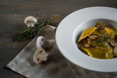 Karanlık ışık arka planda mantarlı makarna mantı. Ev yapımı geleneksel İtalyan yemekleri fotoğraf.