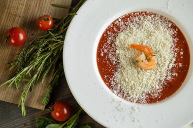 Domates çorbası kruton ekmek ve karides ahşap gri mutfak masasında