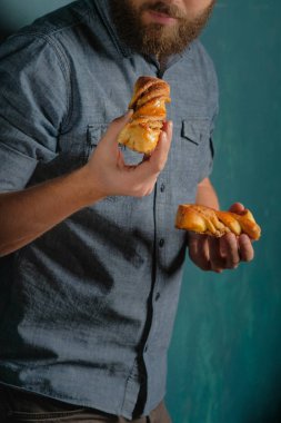 Ev yapımı kekler üzerinde mavi arka plan ayakta elinde tutan adam, kırpma