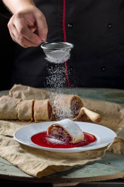 Şef Strudel rustik tarzı mutfağı tablo arka plan üzerinde çilek ile pişirme