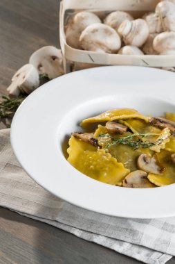 Karanlık ışık arka planda mantarlı makarna mantı. Ev yapımı geleneksel İtalyan yemekleri fotoğraf.