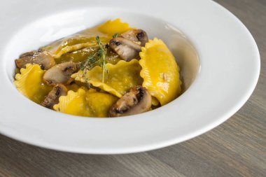 Karanlık ışık arka planda mantarlı makarna mantı. Ev yapımı geleneksel İtalyan yemekleri fotoğraf.