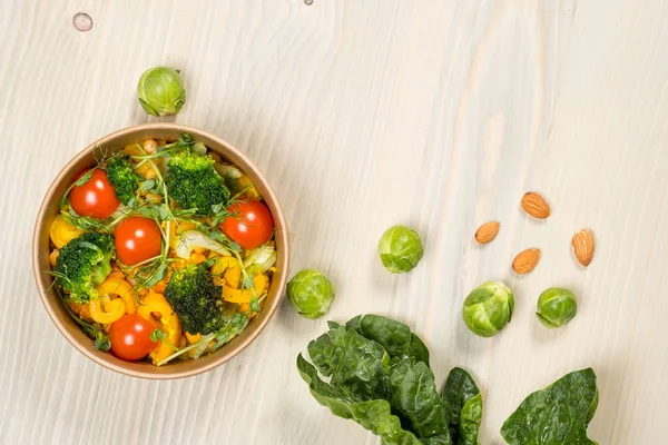 Detox salad with ingredients for vegetarian, vegan food, vitamin snack. Top horizontal view on light wood background. Overhead flat food photo