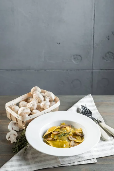 Pasta ravioli with mushrooms in dark light background. Homemade traditional Italian food photo.