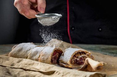 Şef Strudel rustik tarzı mutfağı tablo arka plan üzerinde çilek ile pişirme