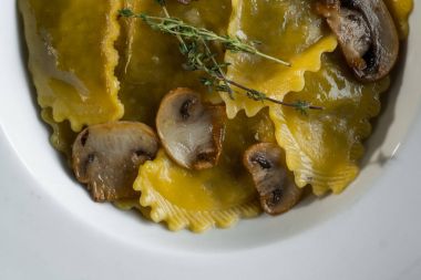 Karanlık ışık arka planda mantarlı makarna mantı. Ev yapımı geleneksel İtalyan yemekleri fotoğraf.