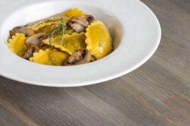 Karanlık ışık arka planda mantarlı makarna mantı. Ev yapımı geleneksel İtalyan yemekleri fotoğraf.