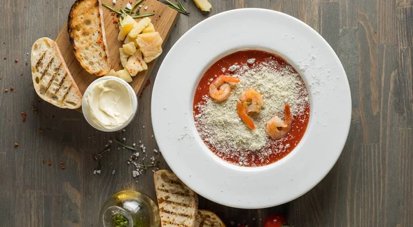 Cooking tomato cream soup on kitchen table with ingredients. Text area space for design menu or recipe