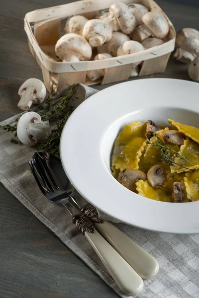 Pasta ravioli with mushrooms in dark light background. Homemade traditional Italian food photo.