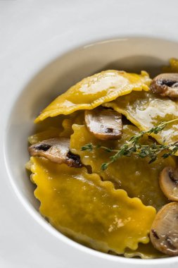 Karanlık ışık arka planda mantarlı makarna mantı. Ev yapımı geleneksel İtalyan yemekleri fotoğraf.