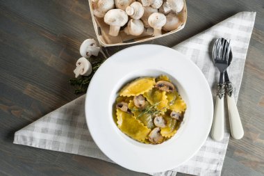 Karanlık ışık arka planda mantarlı makarna mantı. Ev yapımı geleneksel İtalyan yemekleri fotoğraf.