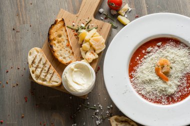 Domates çorbası kruton ekmek ve karides ahşap gri mutfak masasında