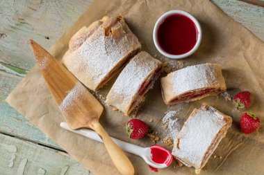 Strudel rustik tarzı mutfağı tablo arka plan üzerinde çilek ile yemek. Yukarıdan düz görünüm, top