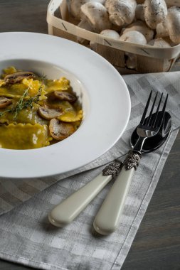 Karanlık ışık arka planda mantarlı makarna mantı. Ev yapımı geleneksel İtalyan yemekleri fotoğraf.